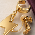 Macro detail of CosNova gold lightning charm chain cuff and padded screw clamp hardware