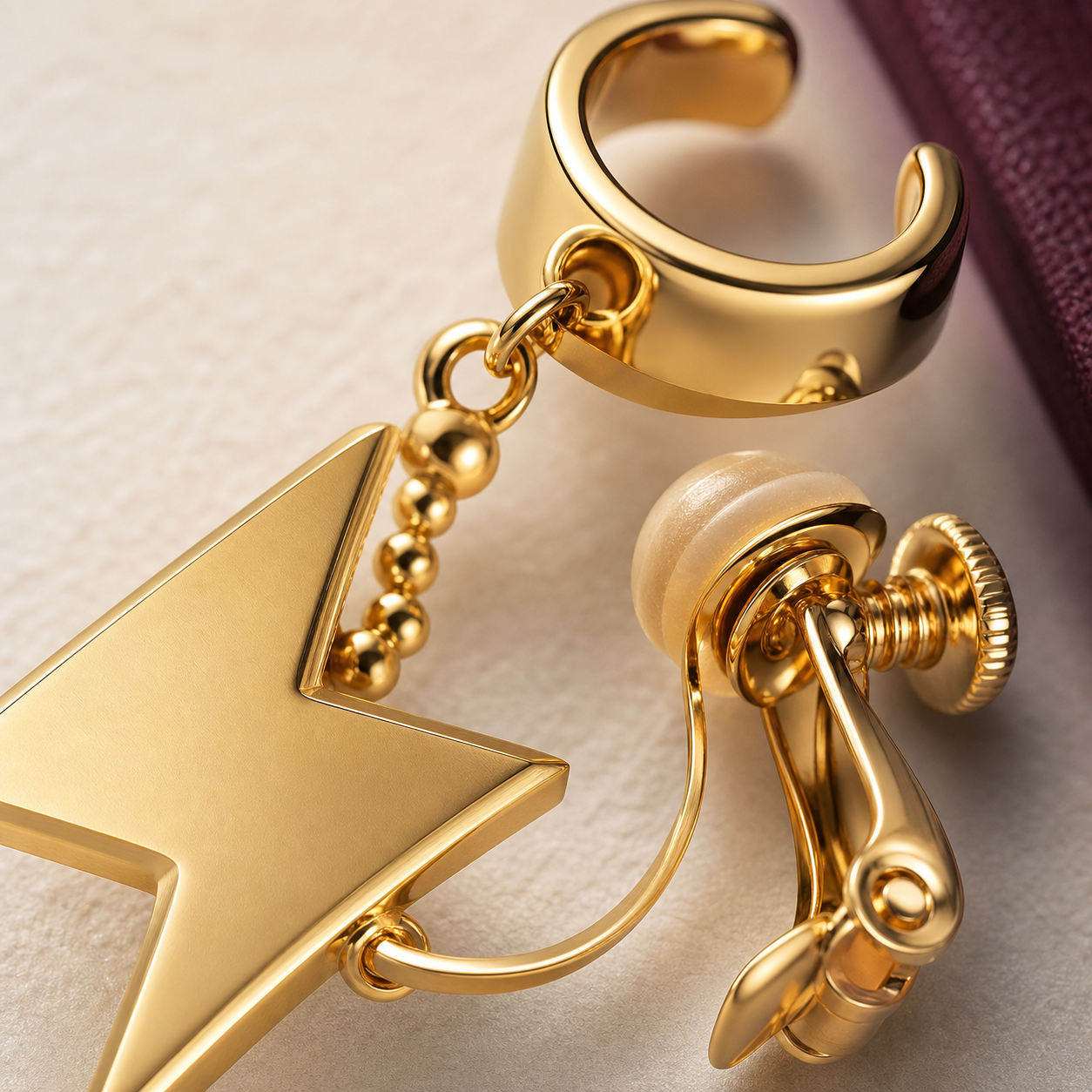 Macro detail of CosNova gold lightning charm chain cuff and padded screw clamp hardware