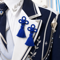 CosNova royal blue knotted tassel brooch pair pinned on navy and white idol-inspired cosplay jacket