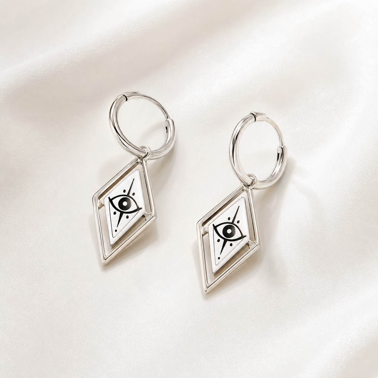 CosNova silver diamond eye hoop earrings pair with white printed diamond charms on satin background